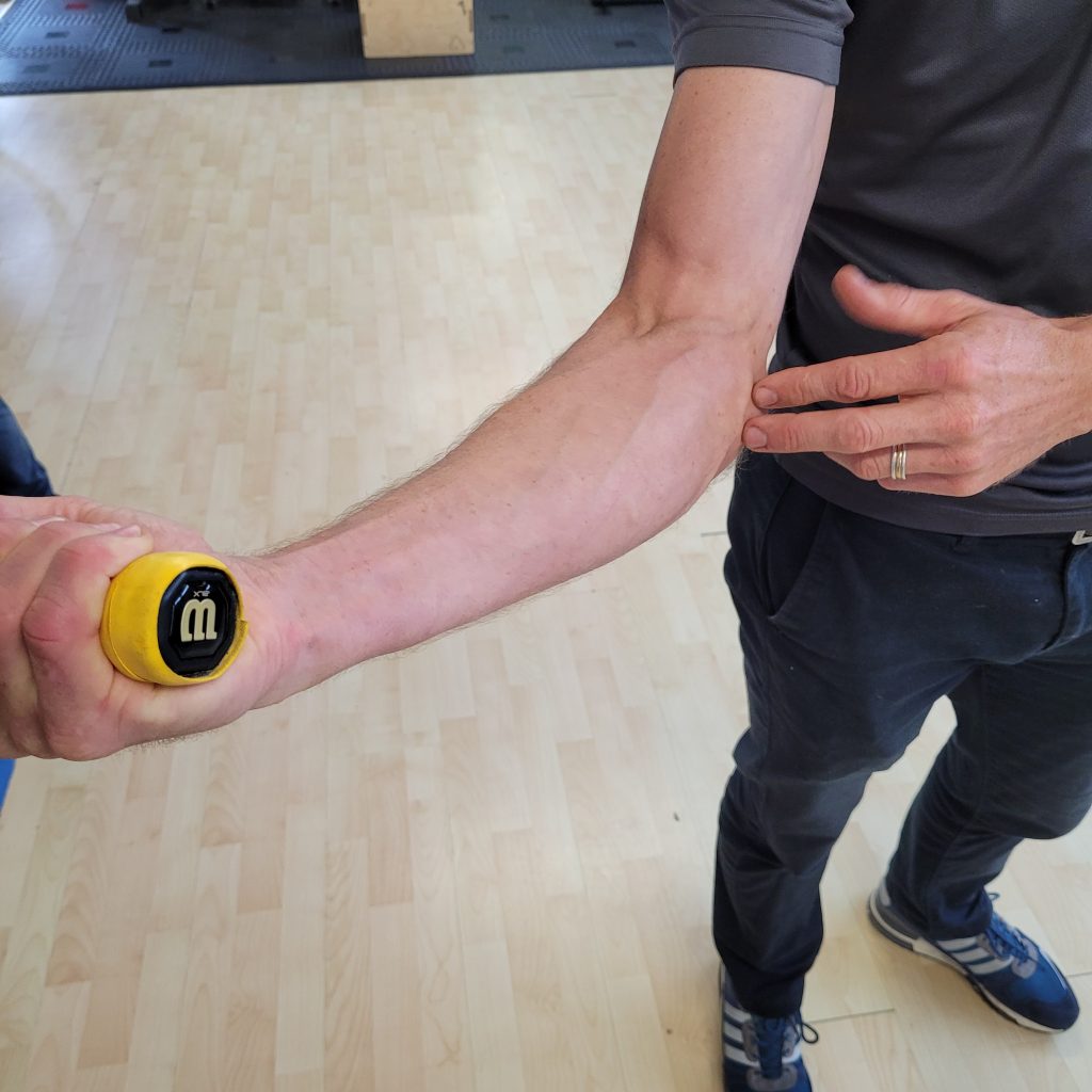 Physio showing elbow pain location on himself